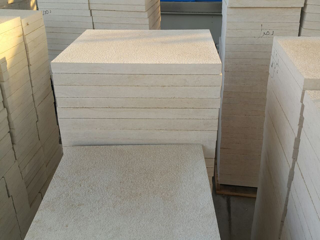 Bush hammered Egyptian marble tiles stacked in factory – rough textured finish
