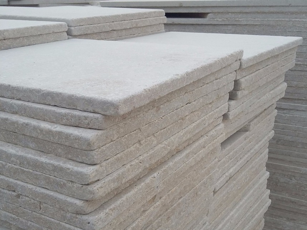 Stack of tumbled Egyptian marble tiles in Cairo factory – rustic natural stone finish